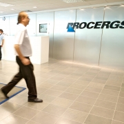 Saguão do prédio sede da Procergs, com funcionário descendo a escadaria principal