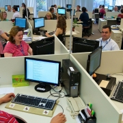 Ambiente com muitos funcionários da Procergs trabalhando em suas mesas com computadores