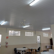 Parte interna de escola pintada em tons de bege com forro em branco.v