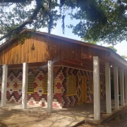 Vista externa da escola, com tijolos coloridos com temática indígena.