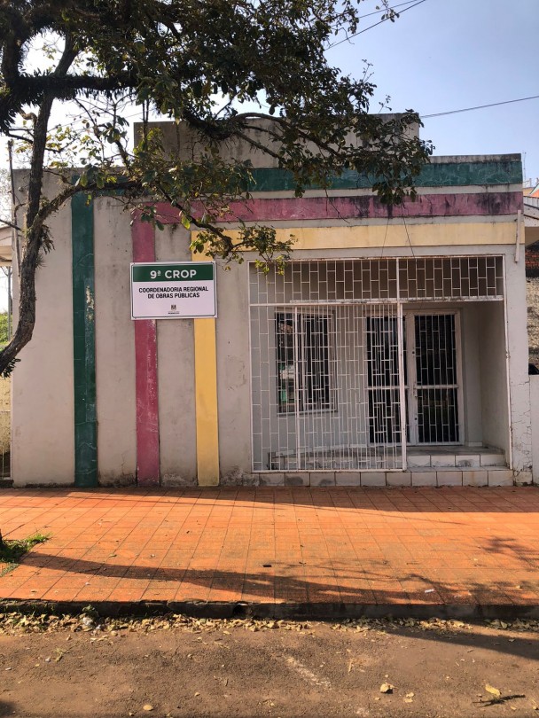 Imagem de um prédio cinza com detalhes em verde, vermelho e amarelo e uma placa identificando a 9ª Crop.