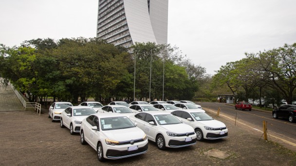 No pátio do CAFF, com o prédio ao fundo, veem-se carros brancos em frente a árvores