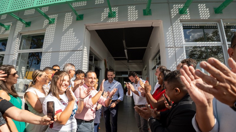 Pessoas se reúnem em frente a um prédio.