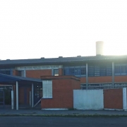 Foto de um prédio escolar de dois pisos, de tijolo à vista, com um letreiro na frente onde se lê CIEP Centro Integrado de Educação Pública.