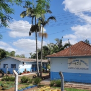 Foto de uma escola composta de três prédios térreos pintados em tons de azul.