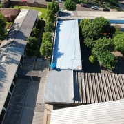 Foto aérea onde se vê os telhados de uma escola.
