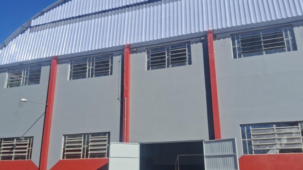 Foto de um ginásio de escola pintado de cinza e vermelho.