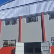 Foto de um ginásio de escola pintado de cinza e vermelho.