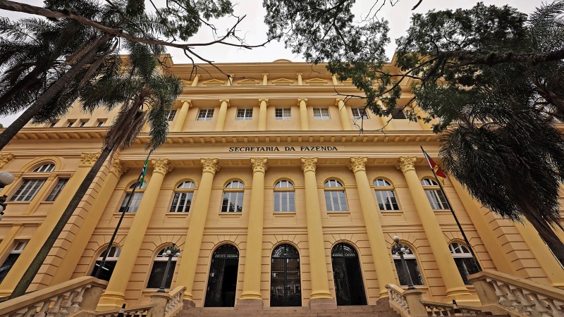 Foto de um prédio em estilo antigo, de quatro pisos e pintado de amarelo.