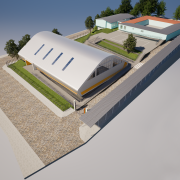 Imagem de uma proje&ccedil;&atilde;o arquitet&ocirc;nica em perspectiva a&eacute;rea de um complexo escolar. Em primeiro plano, destaca-se um gin&aacute;sio coberto com estrutura de grande porte e cobertura curva na cor branca, equipado com claraboias lineares no teto. O edif&iacute;cio &eacute; cercado por &aacute;reas gramadas, cal&ccedil;adas e grades de prote&ccedil;&atilde;o.

Ao fundo, h&aacute; um conjunto de pr&eacute;dios de um pavimento com paredes claras e telhados em tons de cinza e laranja, organizados ao redor de um p&aacute;tio central pavimentado. Entre as edifica&ccedil;&otilde;es, observa-se uma quadra esportiva externa demarcada no piso. O terreno possui acessos pavimentados, cercamento ao longo do per&iacute;metro e &aacute;rvores distribu&iacute;das nas &aacute;reas externas.

A imagem apresenta uma visualiza&ccedil;&atilde;o digital do projeto, utilizada para ilustrar a futura configura&ccedil;&atilde;o do espa&ccedil;o escolar ap&oacute;s as interven&ccedil;&otilde;es e constru&ccedil;&otilde;es previstas.